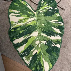 Alfombra con forma de hoja tropical verde y blanca