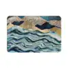 Alfombra baño azul con diseño abstracto de montañas y olas.