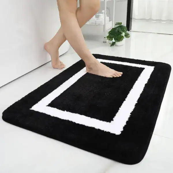 Alfombra de baño blanca y negra con diseño de doble borde cuadrado.