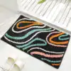 Alfombra baño diseño ondas multicolores fondo negro.