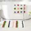 Alfombra de baño con lunares multicolores y rayas.
