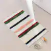 Alfombra baño con rayas multicolores, diseño moderno para cuarto de baño.