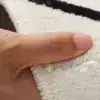 Alfombra baño gato blanco con borde negro, textura suave y tacto agradable.