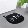 Alfombra baño forma gato negro con detalles blancos.