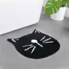 Alfombra baño forma gato negro con detalles blancos.