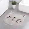 Alfombra baño forma gato gris con patrones negros.