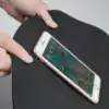 Alfombra de baño gris con diseño texturizado y borde blanco, mostrada con un teléfono móvil.