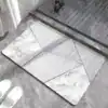 Alfombra baño gris y blanco con diseño geométrico y mármol.