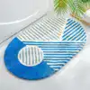 Alfombra de baño ovalada con diseño geométrico en azul y blanco.