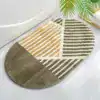 Alfombra de baño ovalada con diseño geométrico en tonos marrones y beige.