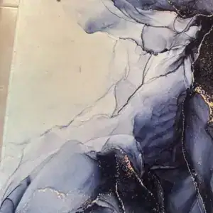 Detalle de una alfombra con estampado de mármol azul y dorado