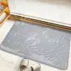 Tapete de baño negro con hojas